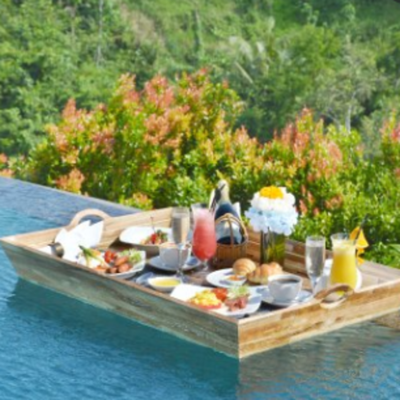 a board with breakfast floating on a pool