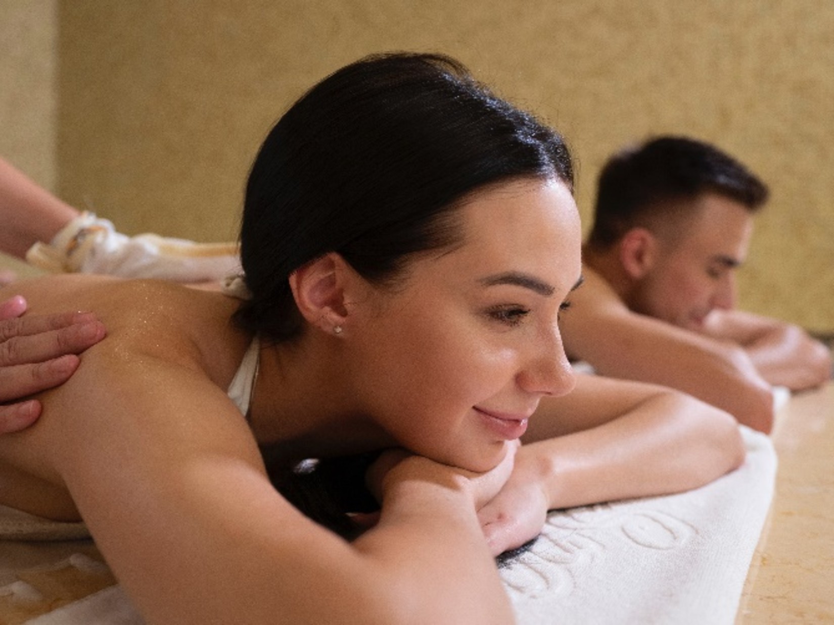 a couple on their backs getting a massage at a spa