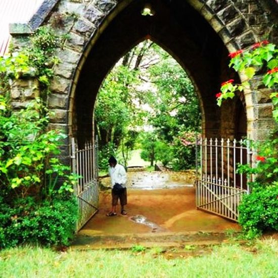 a person in the entrance of tiger hill with a stone arch 