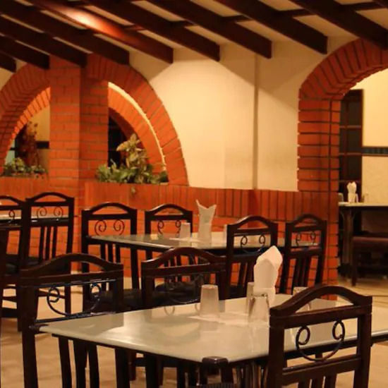 Side view of restaurant Mayura, which has multiple chairs and casual ambience - Hotel Ram International,  Pondicherry