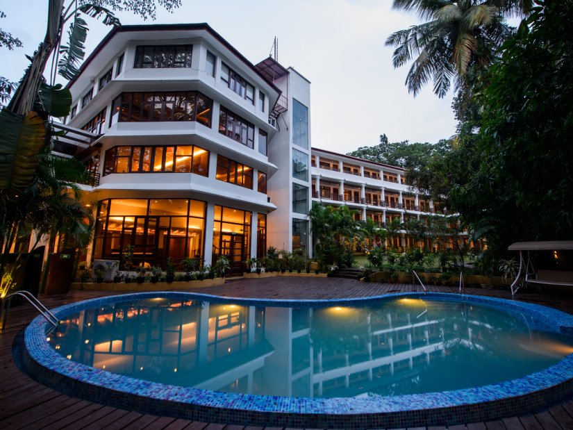 massive outdoor swimming pool surrounded by lush green trees at Hotel Sentinel