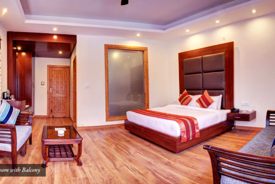 alt-text Side view of Premium room with bed sofas and a large mirror at Summit Chandertal Regency Hotel & Spa