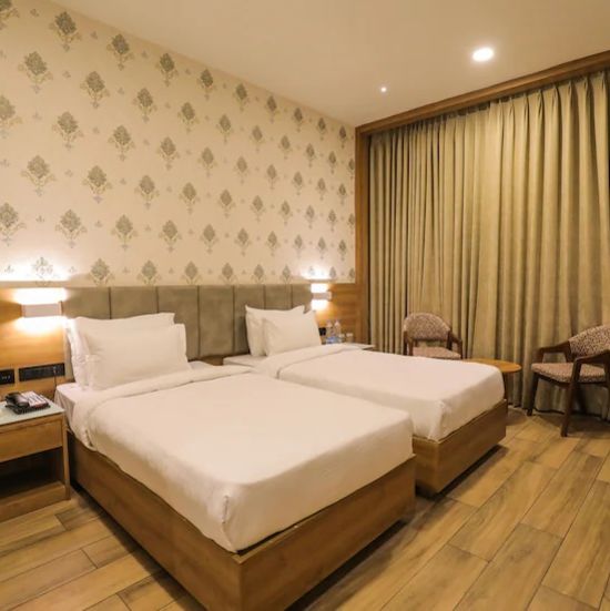 executive twin at Comfort Resort, Morbi displaying two bed placed by a window