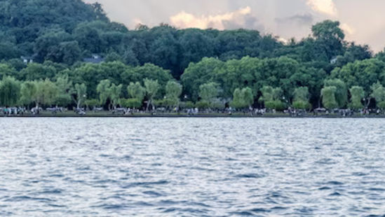 lake in front of forest covered with trees with sun rays shining through the clouds - Chunda Hotels