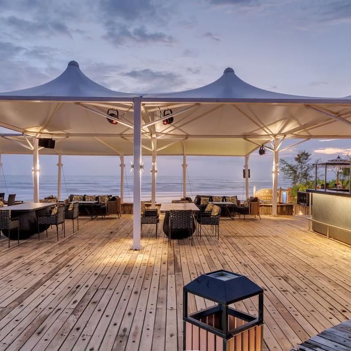 an outside cabana seating arrangement overlooking the beach - Mayfair On Sea, Morjim, Goa