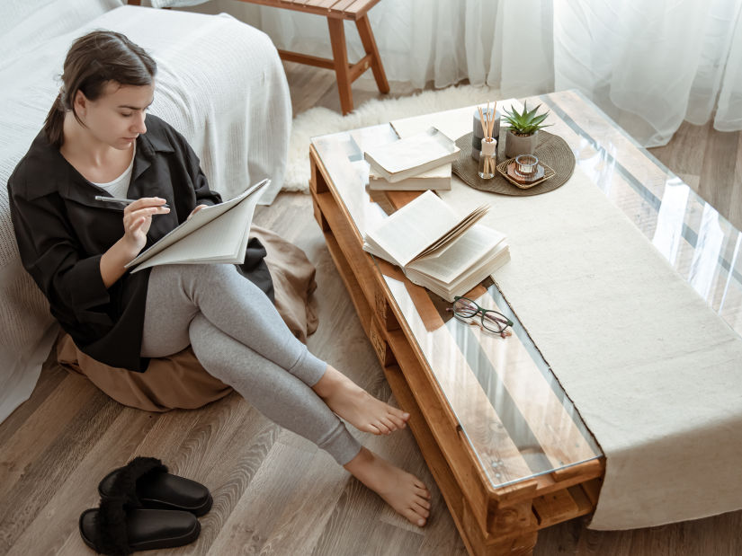 young-female-student-does-assignments-home-sitting-with-notebook-her-hands