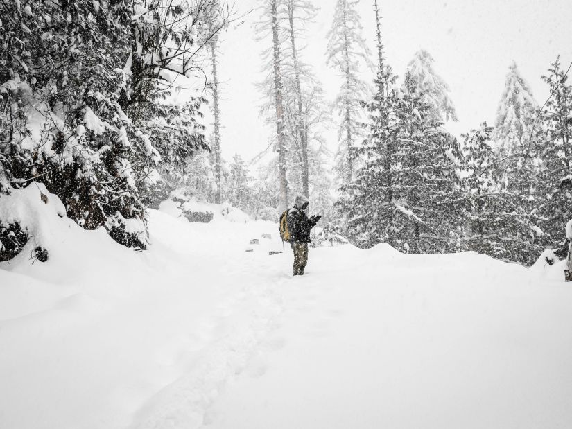 man standing amid thick snow cover