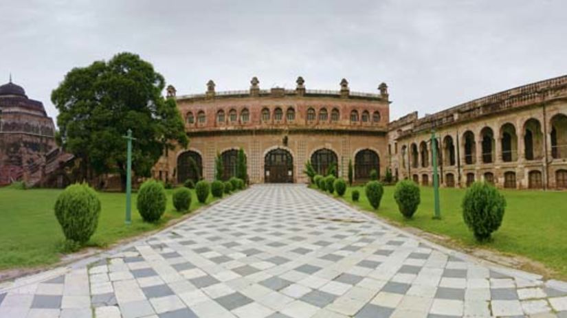 Tiles entrance to the Qila Mubarak with manicured shrubs on the side