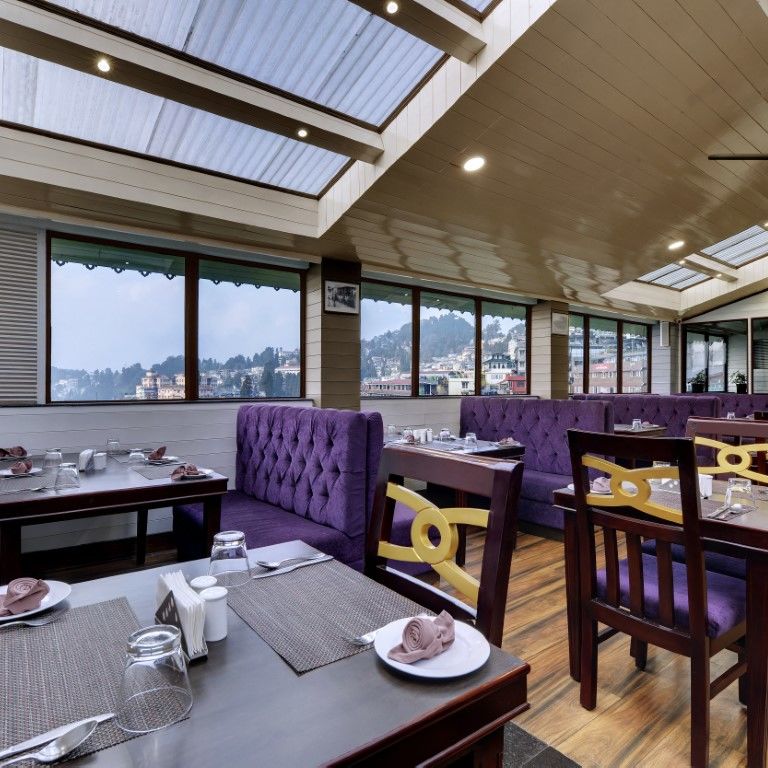 Restaurant Blue charcoal with sofas for seating as well as chairs with tables in the middle  - Sumitel Boutique Resort, Darjeeling