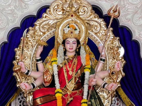 a close up shot of the hindu deity Maa Vaishno Devi with a blue and white background