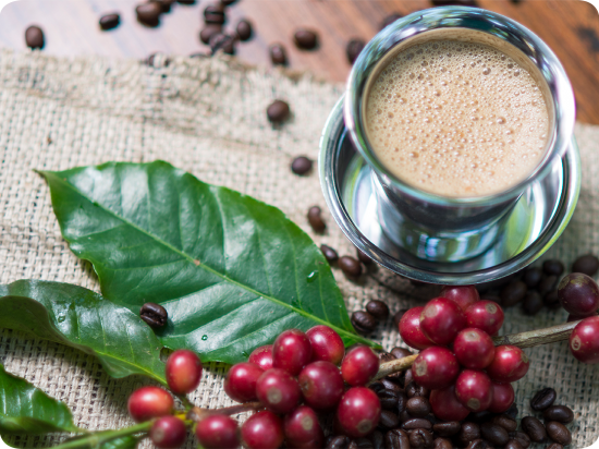 a cup of coffee alongside coffee beans