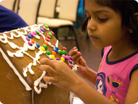 a child decorating a gingerbread house