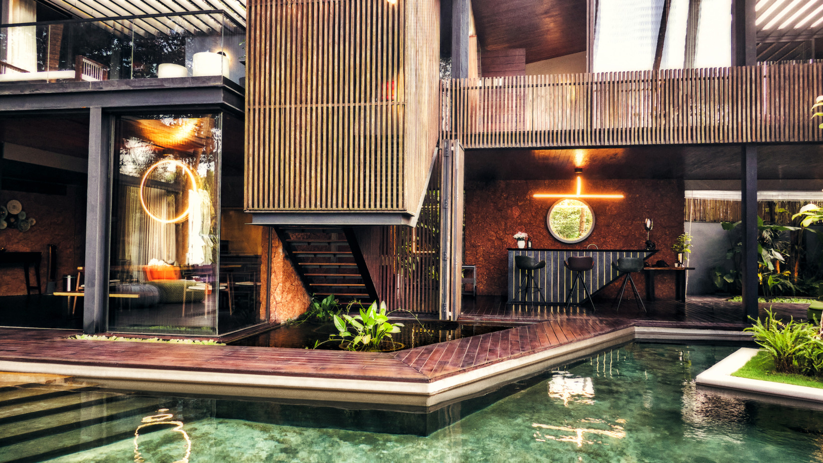 The wooden exterior of the hotel is enhanced by the presence of a decorative water body beneath it - Villa in Palms by V Escapes