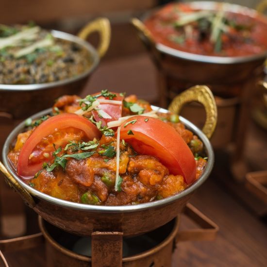 A variety of Indian curries and lentils served in small copper bowls