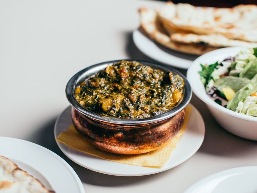 indian curry served on a bowl alongside chapati