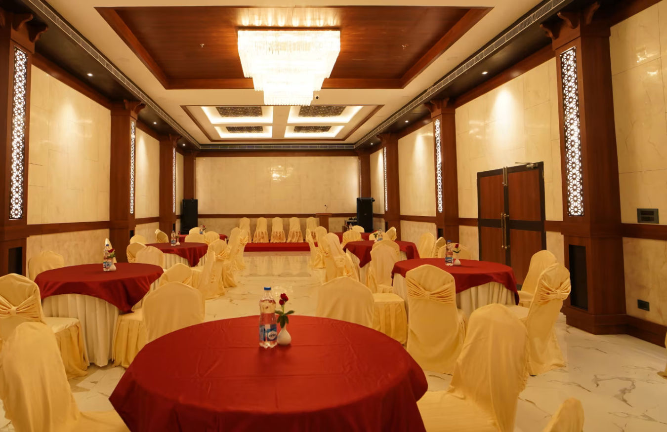 overview of the banquet hall with round table seating arrangement and a chandelier hung above - Shanti Seaview Resort & Spa