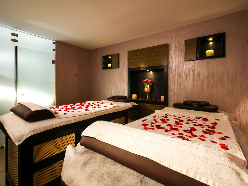 two spa beds with rose petals laid on top of it at a spa 