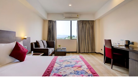 Deluxe room near Vega Circle Mall with a work desk and large bed with a sofa for sitting - Yashshree Milestone, Siliguri