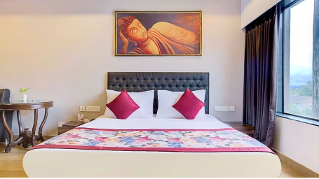 Suite room with a large bed beside which is a window with hillsdie views - Yashshree Milestone, Siliguri