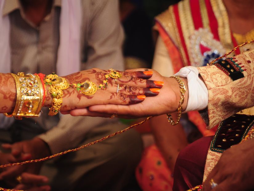 a close up shot of a bride placing her hand on the groom's hand for a wedding ritual