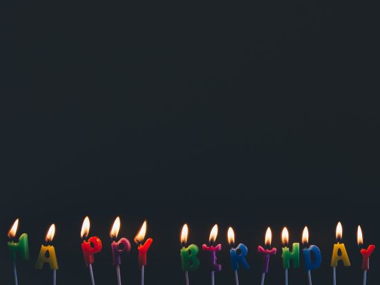 Assorted Candles that are lit with the words happy birthday 