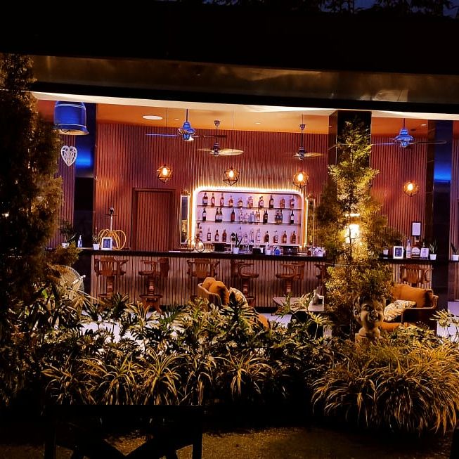 the bar showcasing a rack full of alcohol bottles - Mayfair On Sea, Morjim, Goa