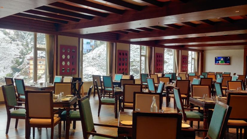 The simple and neat dining arrangements inside a dining venue - The Orchid Hotel Shimla