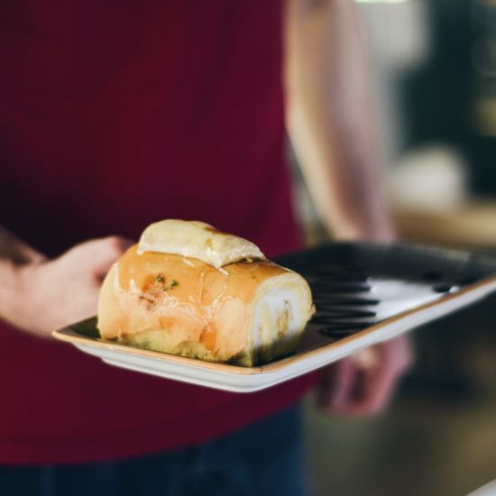 a chef serving food on a small serving plate with the item on it 