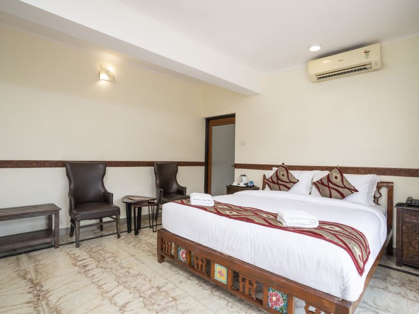 Grand Riverside Bedroom from a different angle shows the chairs and table at the side - Stone Wood Riverfront Resort, Siolim