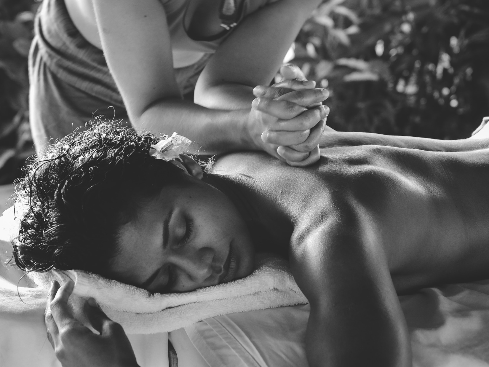 a black and white image of a person receiving a massage 