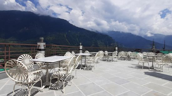 Long shot of Verandah restaurant under blue sky with mountain-view in Manali