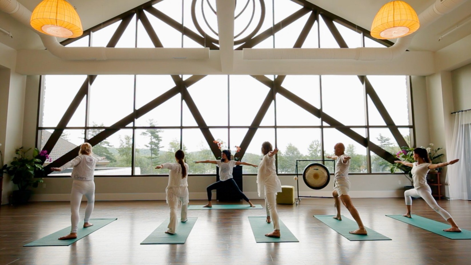 people doing yoga in a quaint room overlooking a beautiful landscape