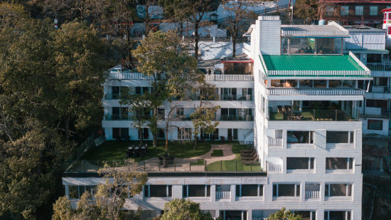 An aerial view of a building with trees around | Sumi Yash Shree Hotels & Resorts