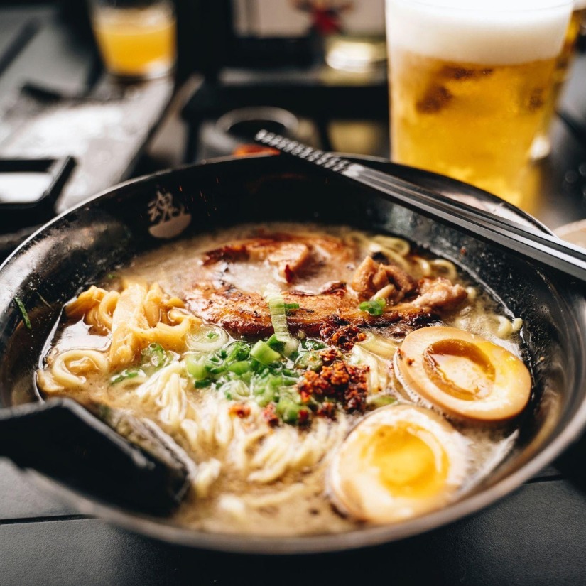 Bowl of ramen served alongside a beer