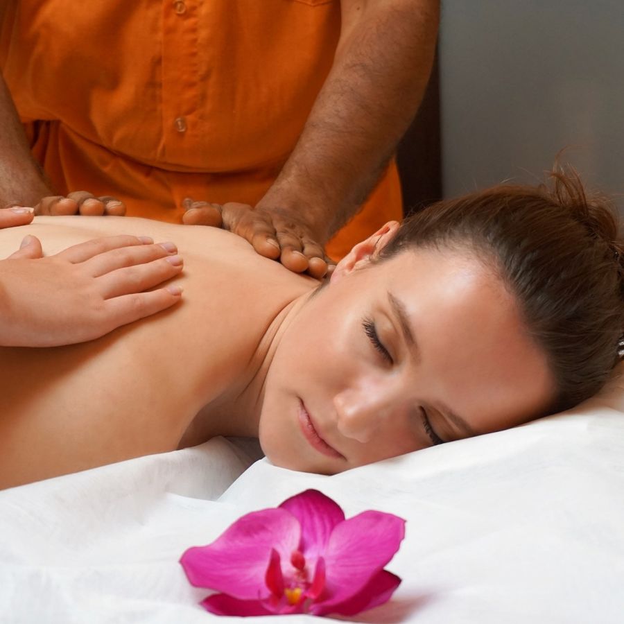 alt-text A woman getting therapeutic treatment by masseuse in a massage bed.