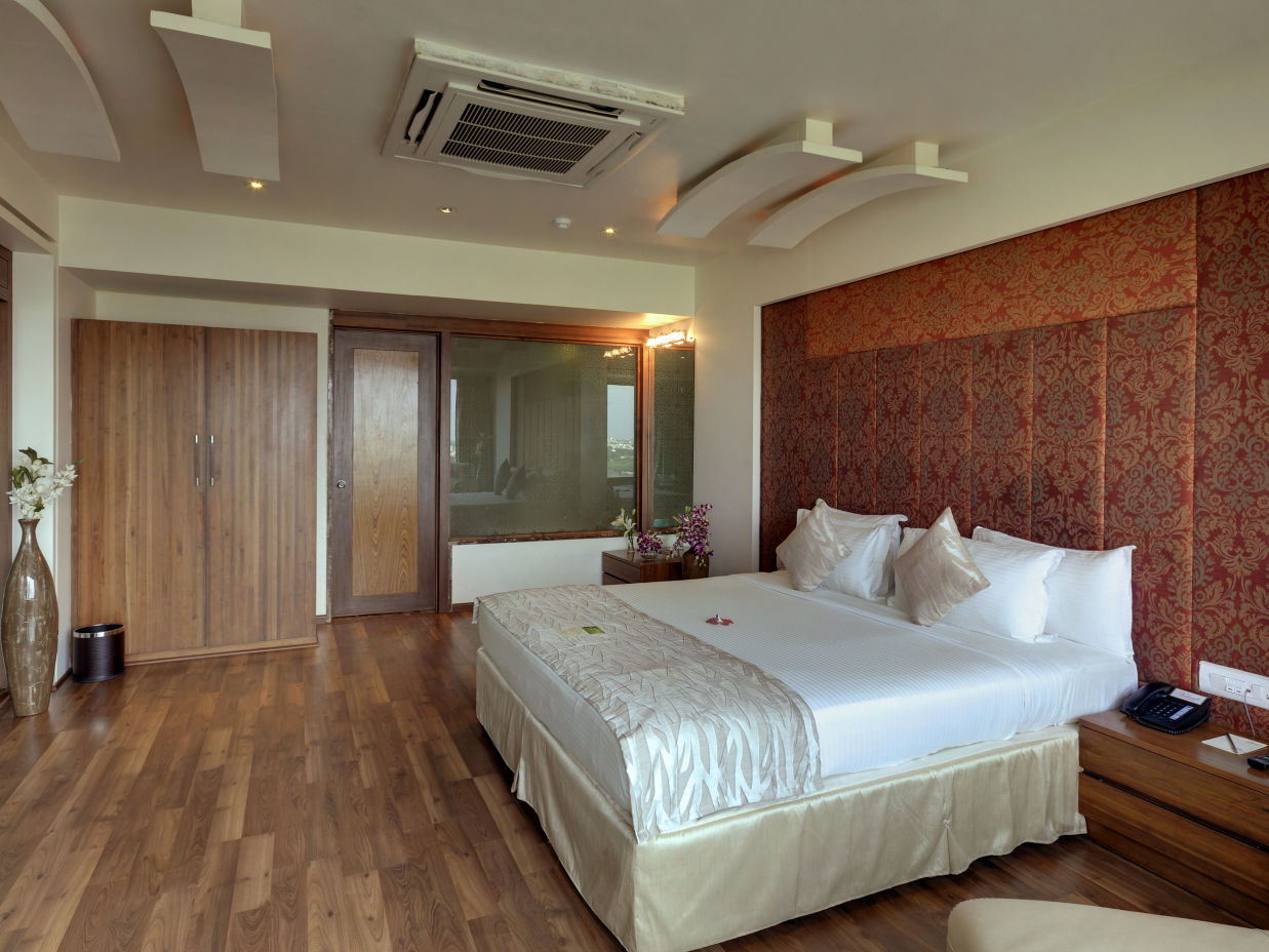 Suite room with brown tones and a white king size bed