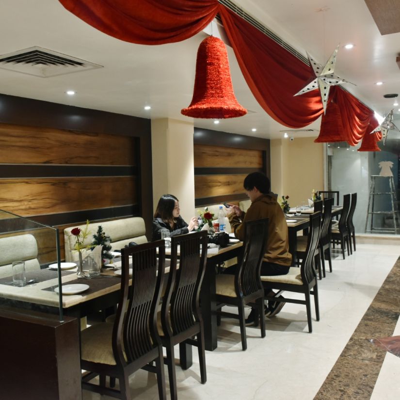 A sideview of tables and chairs at the restaurant | Hotel City Inn, Varanasi