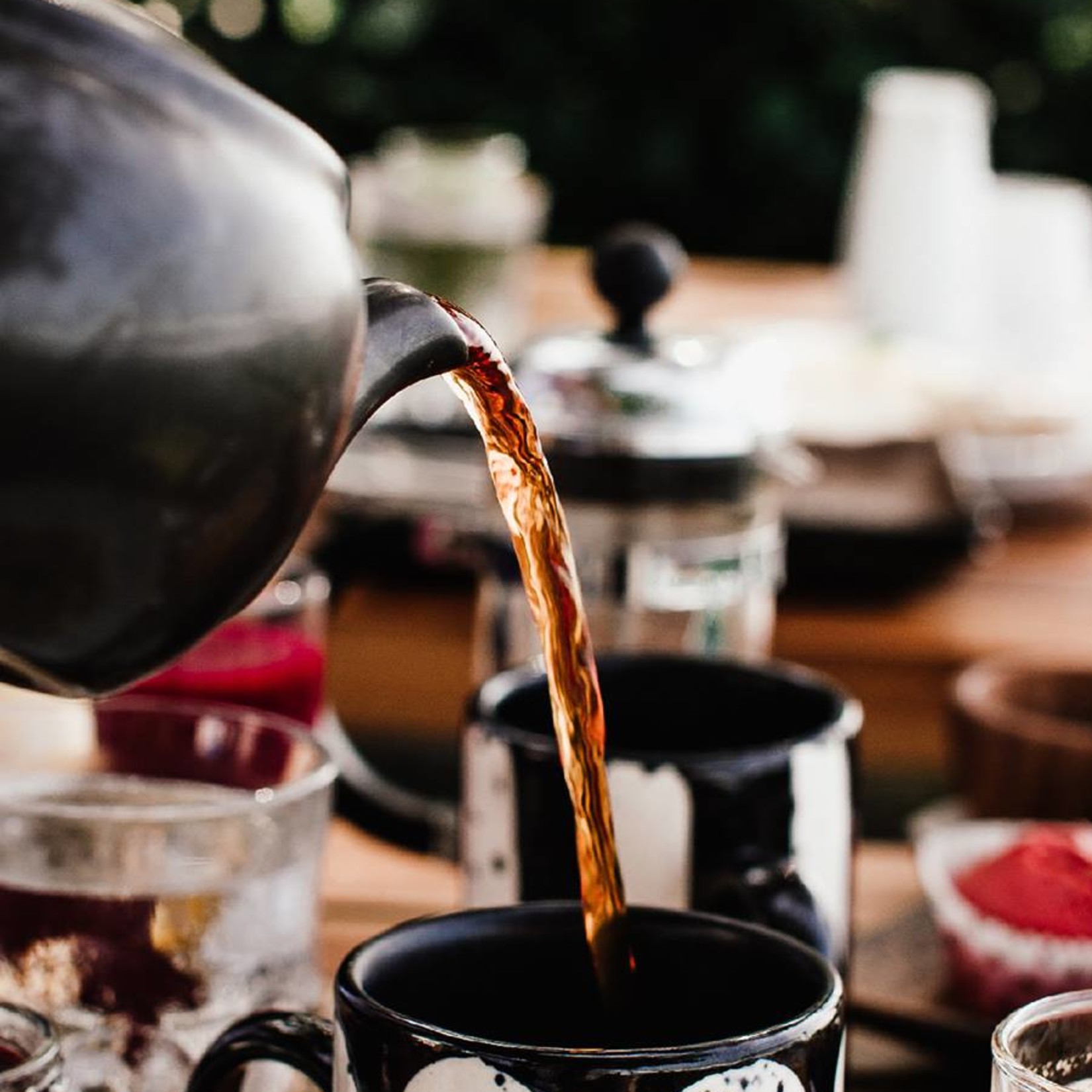 tea being poured into black and white cup