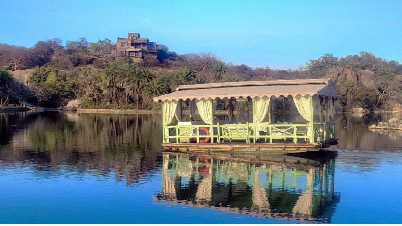 A Boat in a lake during daytime with forest cover in the background - Chunda Shikar Oudi Udaipur