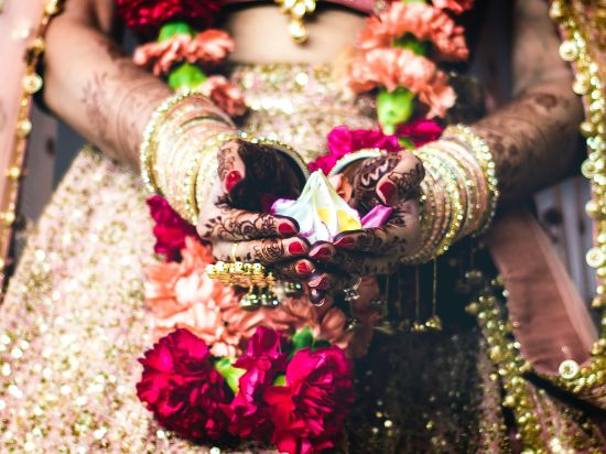 bride holding white flowers for wedding ritual