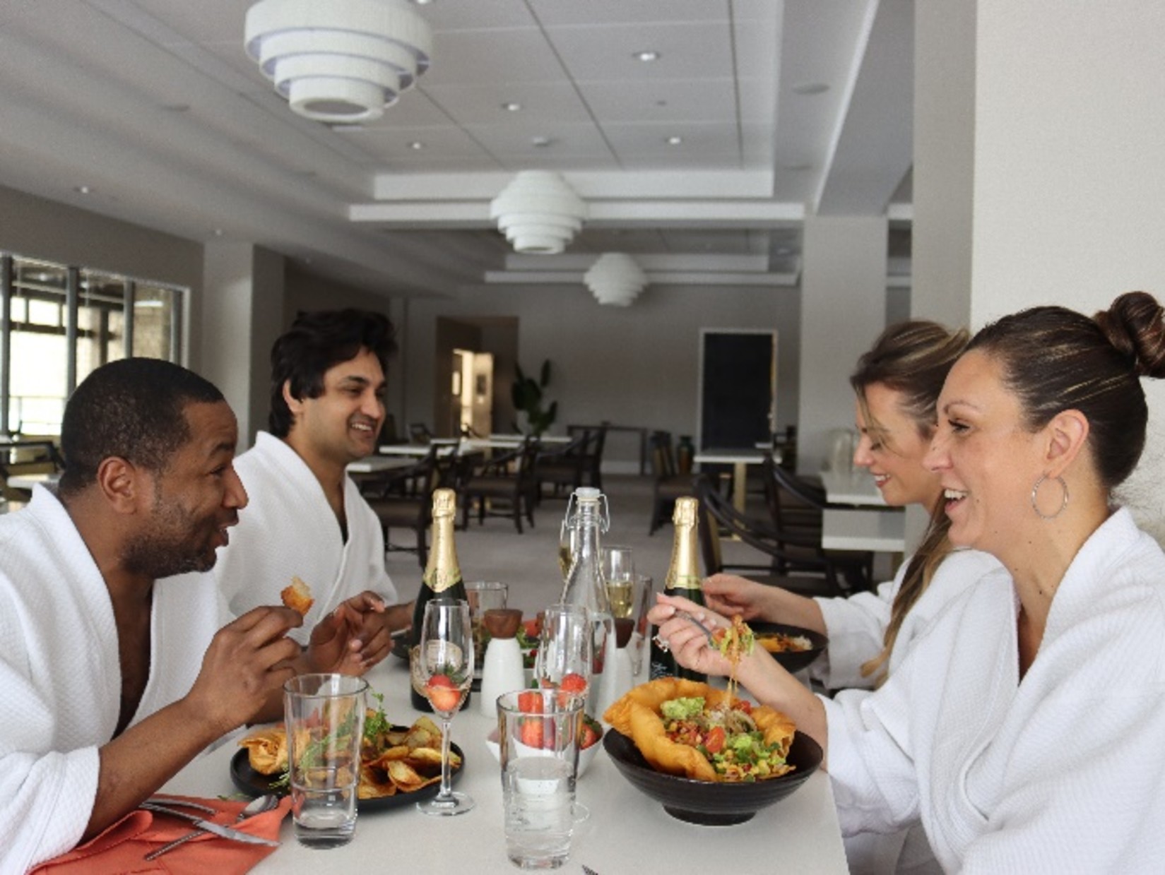 4 people at a dining table enjoying a meal