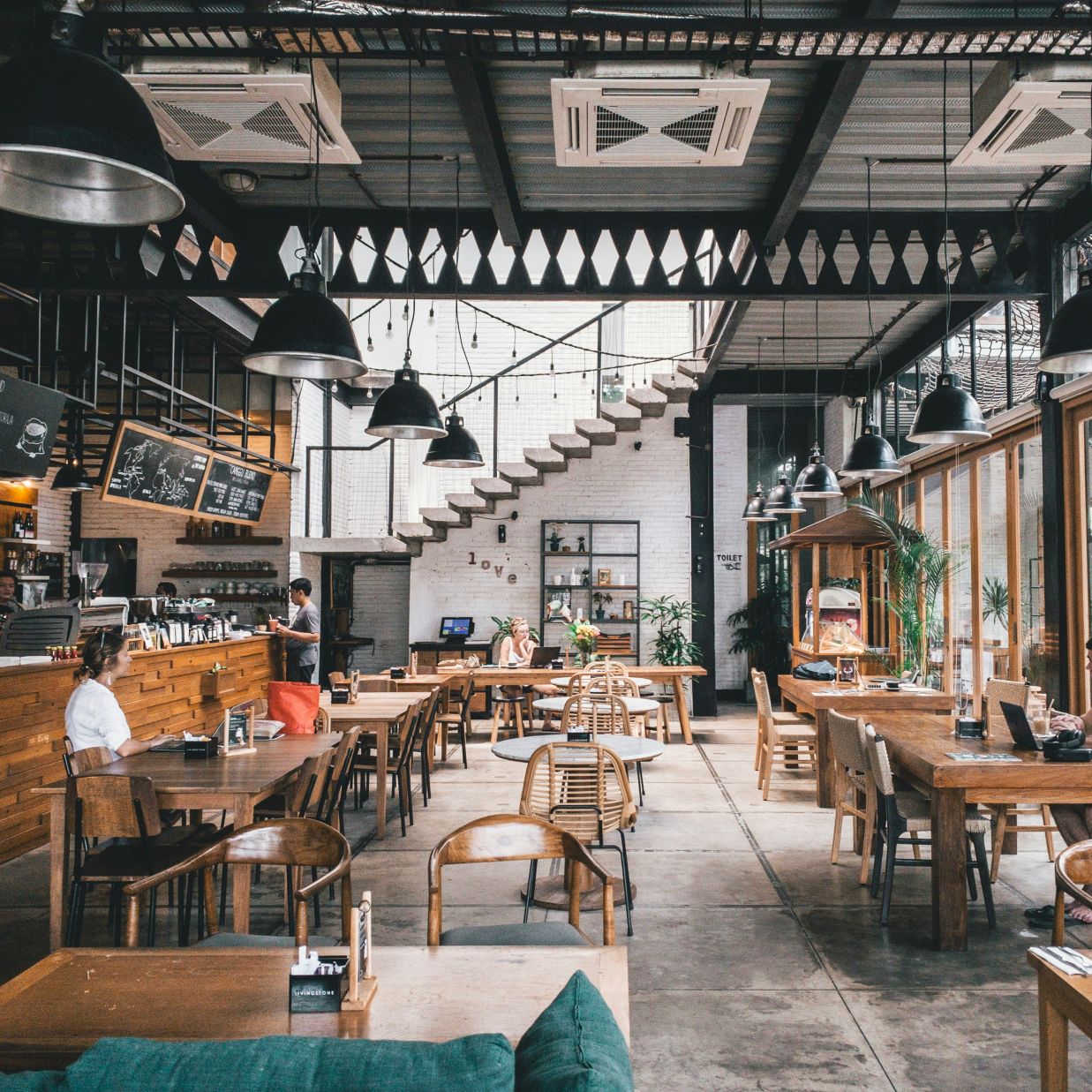 Seating arrangements inside a restaurant with the sun light shining through the windows