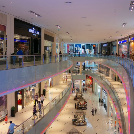 view of a mall with escalators and shops 