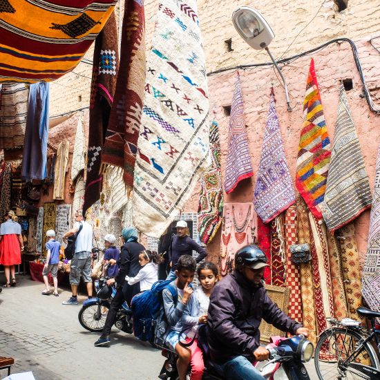 A bustling street with merchandise hanging on the wall