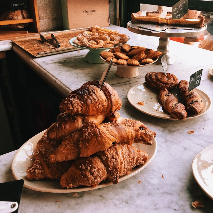 a table with many baked items kept in a plate inside a cafe or a bakery