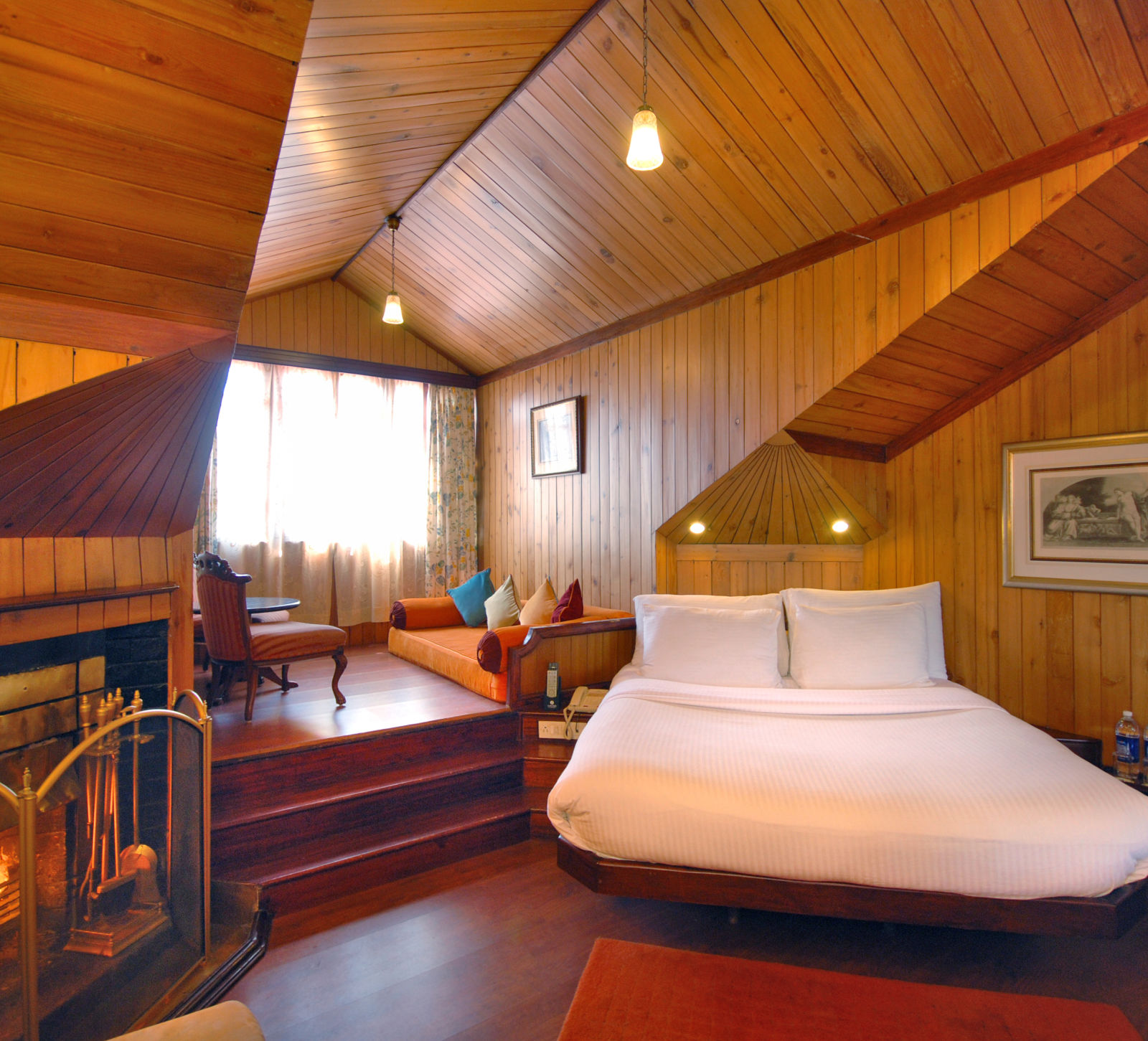 a king size bed and a fireplace to the left - Mayfair Hill Resort, Darjeeling - Luxury Resorts in Darjeeling