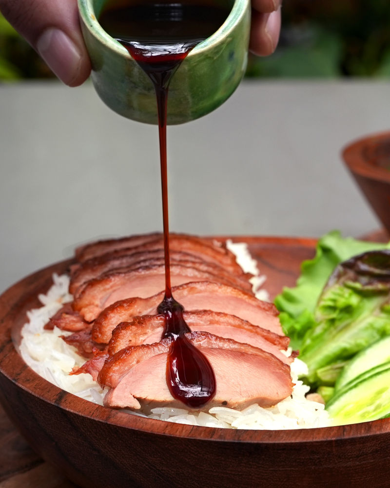 sauce being poured on Hainanse Duck with dip on the side at Village 36