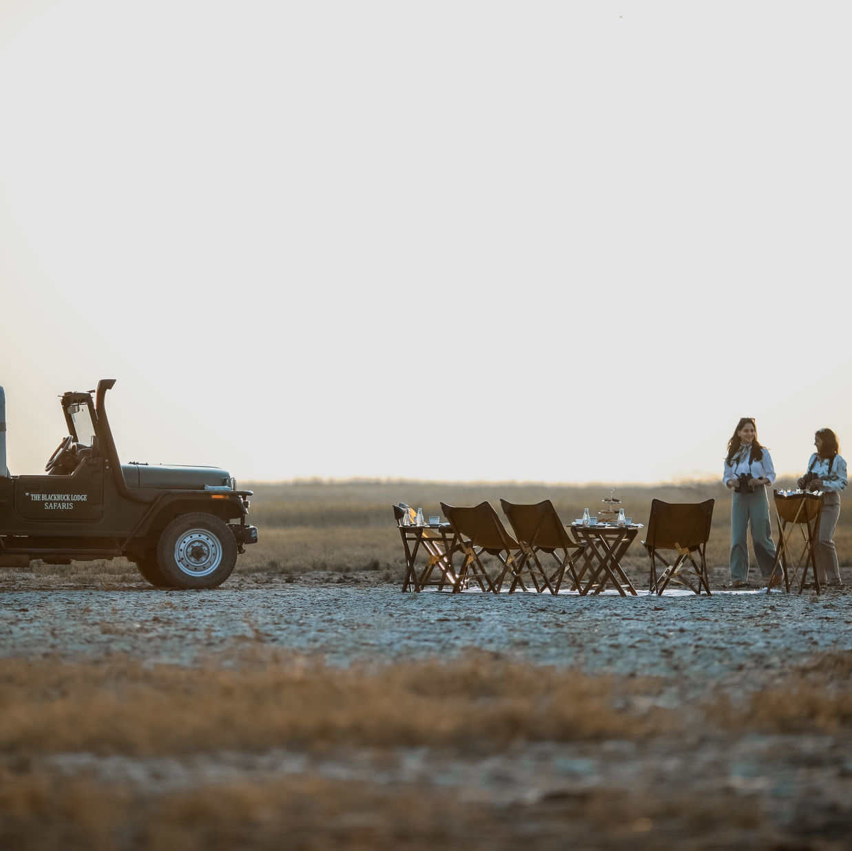 The Blackbuck Lodge - a sundowner area for lunch and two women standing next to a jeep