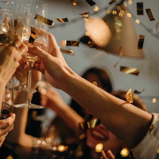 a group of people celebrating while clinking champagne glasses