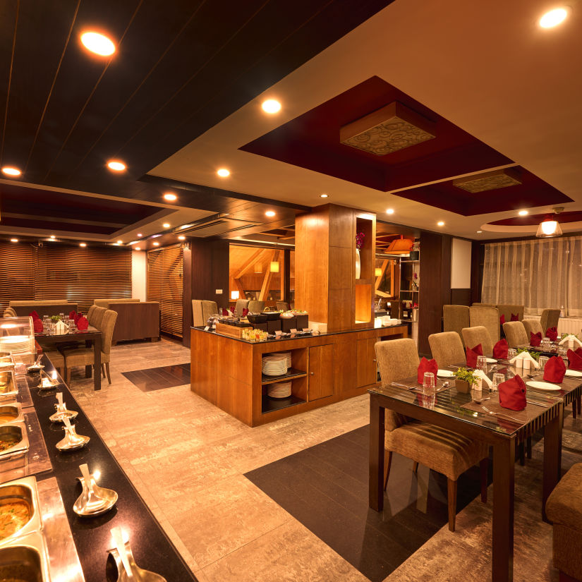 Renest Manali - interior view of the in-house restaurant, tribe containing provisions for buffet meals and numerous seating options